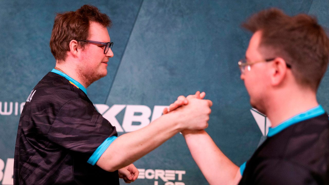 Two men handshaking in matching shirts